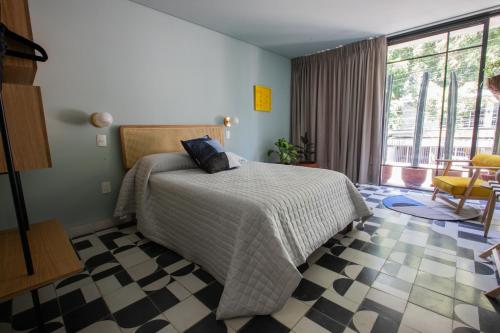 a bedroom with a bed with a checkered floor at Casa Ixaya by Barrio México in Guadalajara