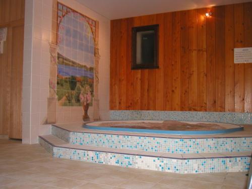 une baignoire jacuzzi dans une chambre avec des murs en bois dans l'établissement Hotel Lou Granva, à Grande-Rivière