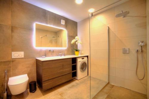 uma casa de banho com um lavatório e uma máquina de lavar roupa em Apartments Villa Rojnica em Jelsa