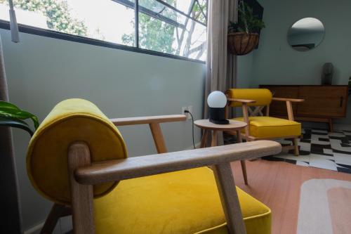 a classroom with yellow chairs and a whiteboard at Casa Ixaya by Barrio México in Guadalajara