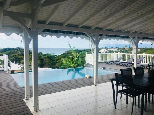 a patio with a table and chairs and a swimming pool at VILLA TI PUNCH in Sainte-Anne