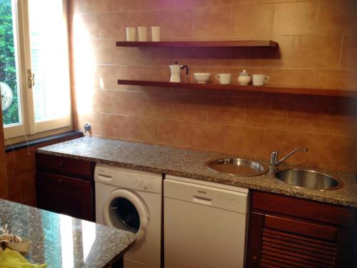 uma cozinha com um lavatório e uma máquina de lavar roupa em Large Apartment (3 bedrooms - 2 bathrooms), 50 meters from the beach em Paraggi