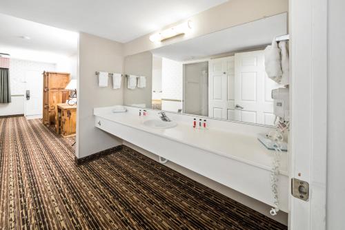 a bathroom with a sink and a large mirror at Days Inn by Wyndham Lebec in Grapevine