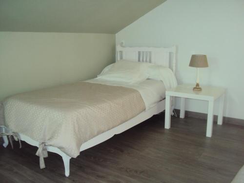 a bedroom with a bed and a table with a lamp at Le Saint Aubin- Maison d hôtes dans ce monastère du 16 siècle in Amfreville-la-Campagne