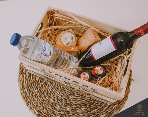 a basket with a bottle of wine and a glass at Casa das Laranjeiras in Alfarim