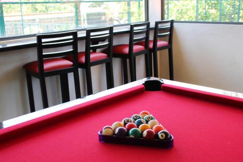 a pool table with two chairs and a table with balls at Hotel Boutique La Rioja in Atlixco