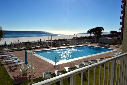 a view of a swimming pool with chairs and the beach at Sunswept 203 Condo in Orange Beach