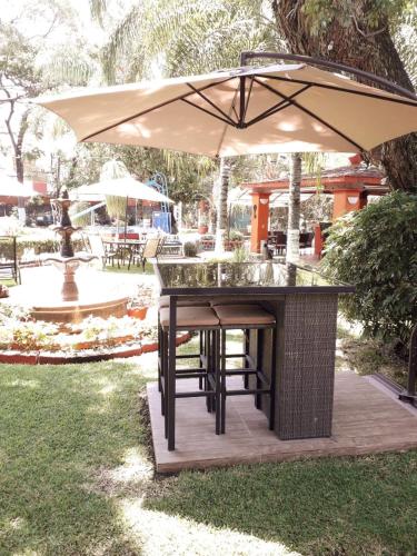an outdoor bar with an umbrella on a deck at Villa Paraiso in Emiliano Zapata