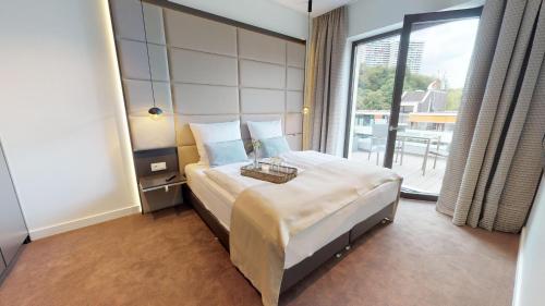 um quarto com uma cama grande e uma janela grande em White Pearl Apartment 4.50 em Timmendorfer Strand