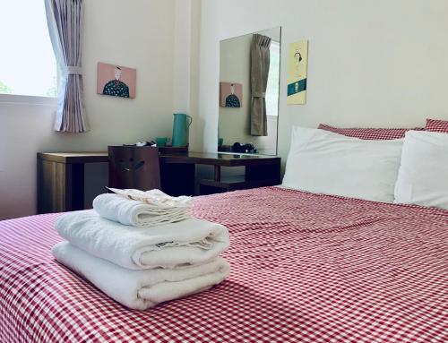 a pile of towels sitting on top of a bed at Puli Islet Inn in Puli