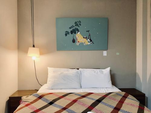 a bedroom with a bed and a painting on the wall at Puli Islet Inn in Puli