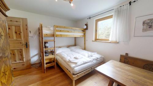 a room with a bunk bed and a table at Stambuoch 3 in Celerina