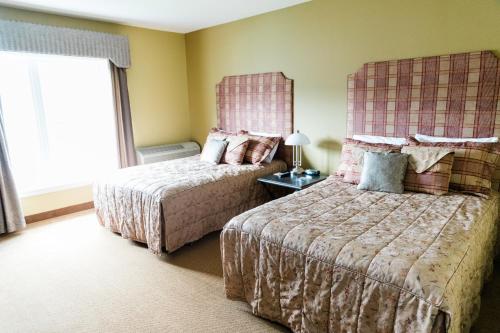 um quarto de hotel com duas camas e uma janela em The Lakes at Ben Eoin Golf Club & Resort em Sydney Forks