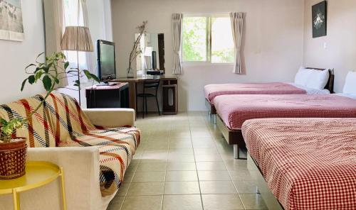 a hotel room with two beds and a couch at Puli Islet Inn in Puli