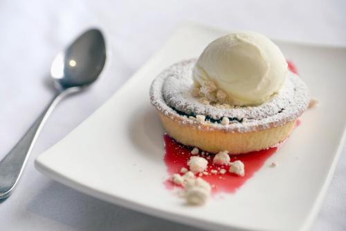 a cupcake with a scoop of ice cream on a plate at Thredbo Alpine Hotel in Thredbo