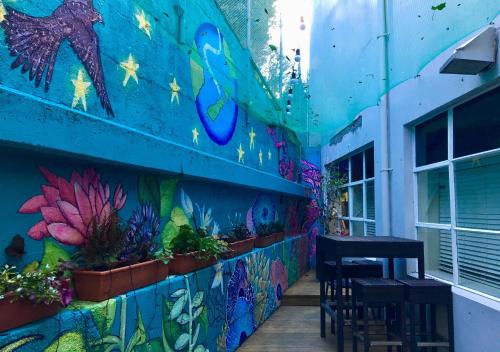 a mural on the side of a building with chairs and plants at Trek Global Backpackers in Wellington