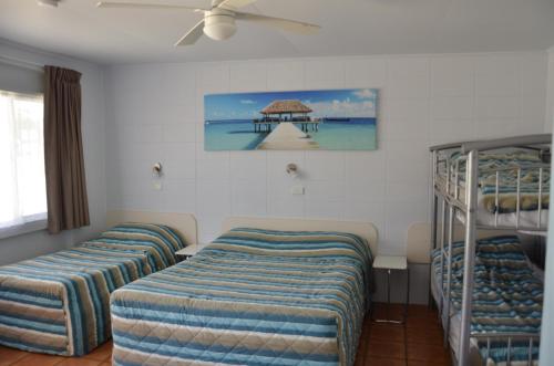 a room with three bunk beds and a ceiling fan at Sunburst Motel in Gold Coast