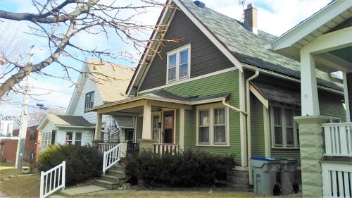 a green house with a gray roof at Comfortable 3 BR Craftsman Bungalow in Milwaukee's Bay View Neighborhood in Milwaukee