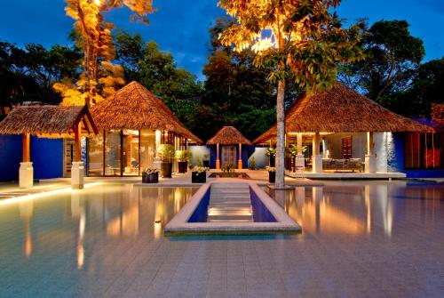 a resort with a swimming pool at night at Sri Panwa Phuket Luxury Pool Villa Hotel - SHA Plus in Panwa Beach