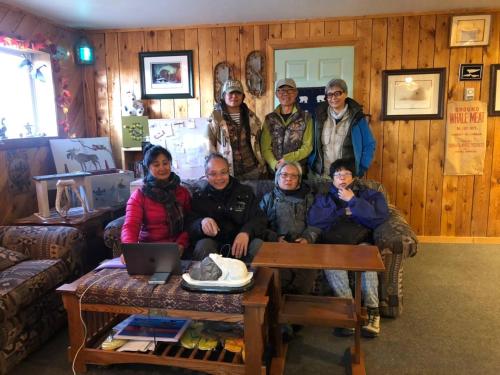 a group of people posing for a picture in a living room at IceBerg Inn in Churchill
