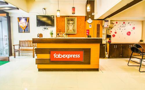 FabExpress Karishma Rasta Peth في بيون: مطعم مع كاونتر لوبيز في بهو الفندق