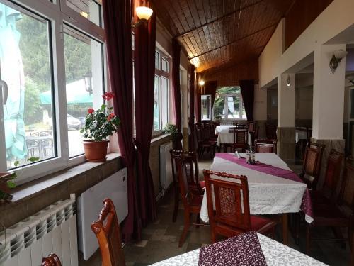 een restaurant met tafels en stoelen en een raam bij Floarea Reginei in Sîmbăta de Sus