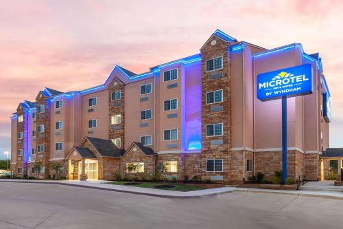 a hotel with a sign in front of a building at Microtel Inn & Suites by Wyndham College Station in College Station