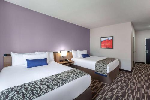 a hotel room with two beds in a room at Microtel Inn & Suites by Wyndham College Station in College Station