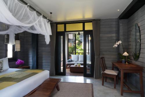 a bedroom with a bed and a living room at Anantara Lawana Koh Samui Resort in Chaweng