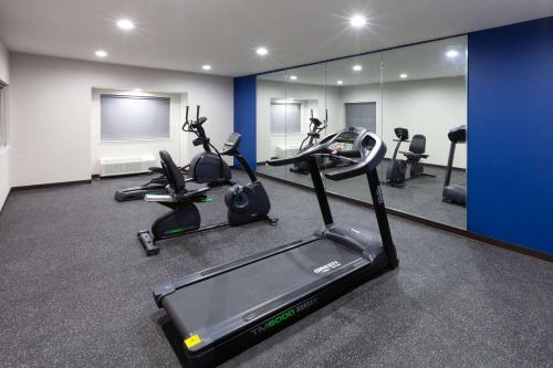 a gym with treadmills and ellipticals in a room at Microtel Inn & Suites by Wyndham College Station in College Station