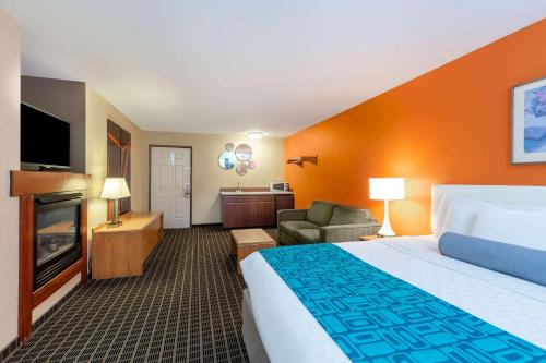 a hotel room with a bed and a couch and a television at Howard Johnson by Wyndham Leavenworth in Leavenworth