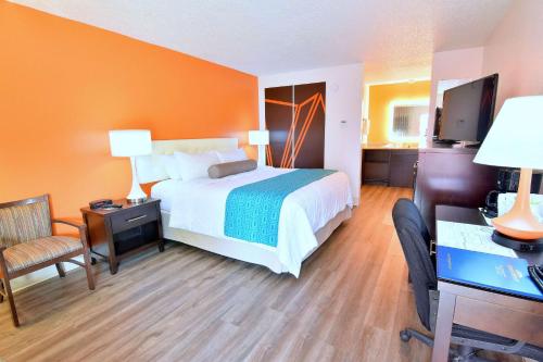 a hotel room with a bed and a desk and chair at Howard Johnson by Wyndham Ocala FL I-75 in Ocala