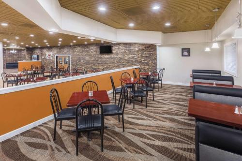 un ristorante con tavoli e sedie e un bar di AmericInn by Wyndham Janesville a Janesville