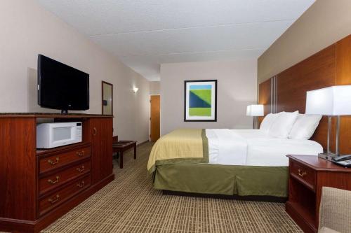 a hotel room with a bed and a flat screen tv at Baymont by Wyndham Elkhart in Elkhart