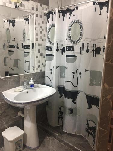 a bathroom with a sink and a shower curtain at Joni's house in Piqeras