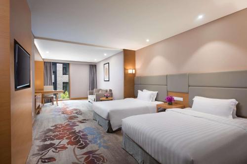 Un ou plusieurs lits dans un hébergement de l'établissement Ramada by Wyndham Beijing Airport