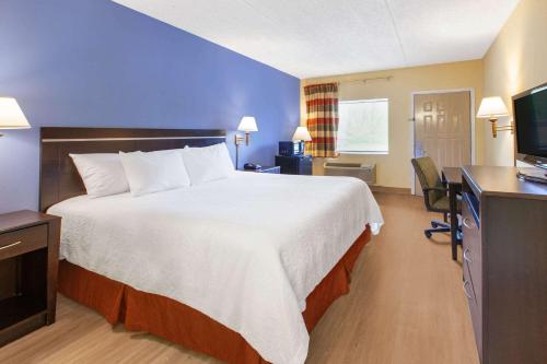 a hotel room with a large bed and a desk at Days Inn by Wyndham Grantville in Grantville