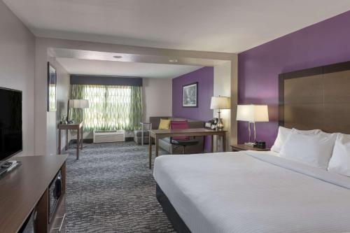a hotel room with a large bed and a desk at La Quinta by Wyndham Visalia/Sequoia Gateway in Visalia