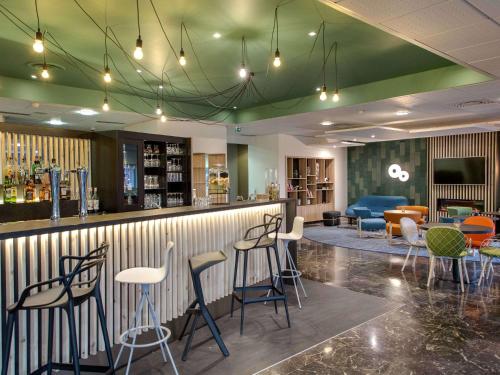 a lobby with a bar with chairs and tables at Mercure Cavaillon in Cavaillon