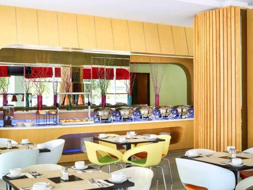 a restaurant with tables and chairs and a counter at ibis Styles Yogyakarta in Yogyakarta