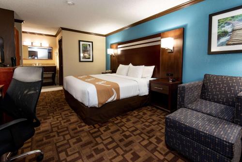 une chambre d'hôtel avec un lit et une chaise dans l'établissement Quality Inn & Suites Quakertown-Allentown, à Quakertown