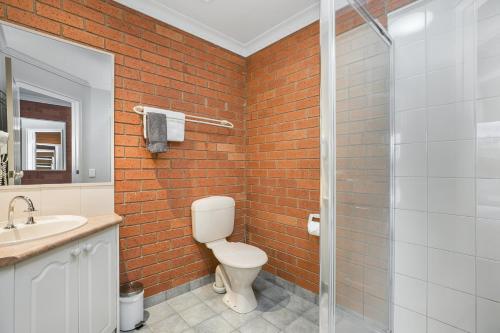a bathroom with a toilet and a glass shower at Bendigo Goldfields Motor Inn in Bendigo