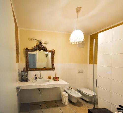uma casa de banho com um lavatório, um WC e um espelho. em Villa Miriam em Levico Terme