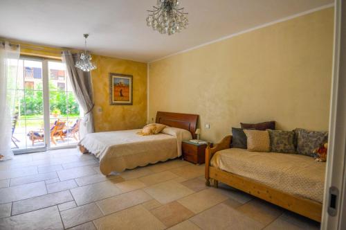 a bedroom with a bed and a couch and a window at Villa Miriam in Levico Terme