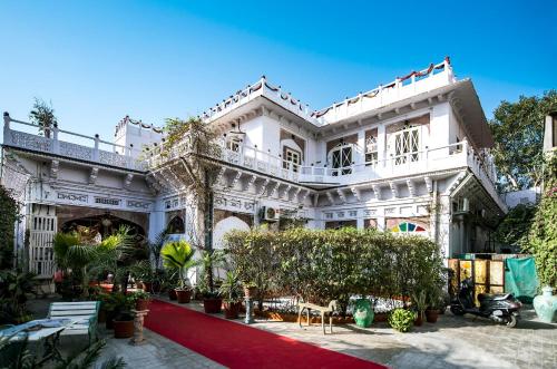 een groot wit gebouw met rode loper bij The Kothi Heritage in Jodhpur