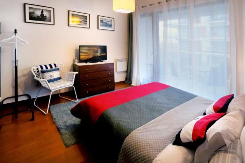 sypialnia z łóżkiem, telewizorem i krzesłem w obiekcie Apartament Baltic Park Plaża 1.1.1 w Świnoujściu