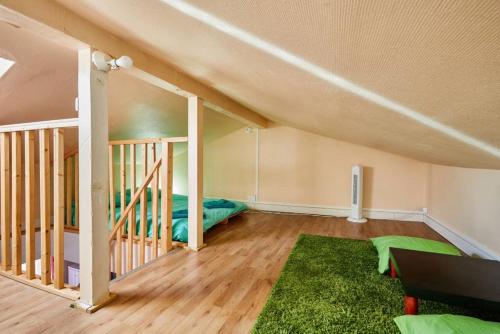 an attic room with a bed and a green rug at Cosy Home - PantinSmile in Pantin