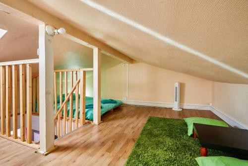 une chambre mansardée avec un lit et un tapis vert dans l'établissement Cosy Home - PantinSmile, à Pantin