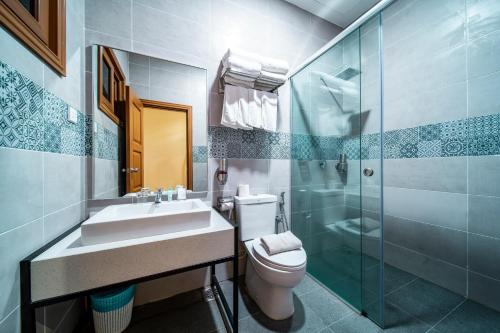 a bathroom with a toilet and a sink and a shower at Aman Tioman Beach Resort in Tioman Island