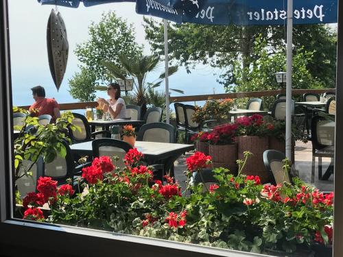 a window view of a patio with tables and flowers at Hotel-Berggasthof Schwarzwaldperle in Sasbachwalden